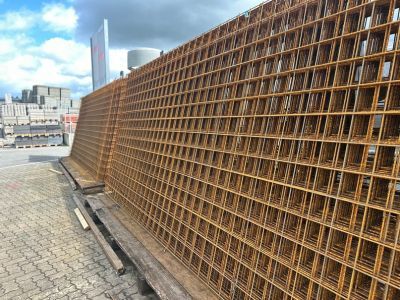 Stahlgitter gestapelt auf Pflasterfl&auml;che im Freien, Baumaterial f&uuml;r Bewehrung bei Bauprojekten.