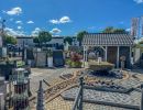 Gartencenter zeigt Pflastersteine, Brunnen und Dekoartikel im Au&szlig;enbereich unter klarem Himmel