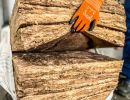 D&auml;mmmaterial wird von behandschuhten H&auml;nden verarbeitet &ndash; zeigt W&auml;rmed&auml;mmung zur Energieeinsparung im Bau