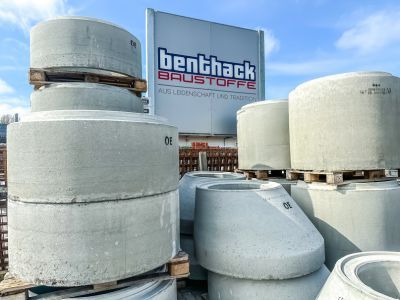 Gro&szlig;e Betonrohre liegen gestapelt im Au&szlig;enlager &ndash; zeigt Materialien f&uuml;r den Tiefbau und Infrastrukturprojekte