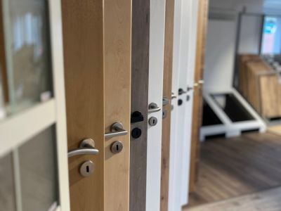 Mehrere Holzt&uuml;ren in verschiedenen Farben und Designs nebeneinander ausgestellt zur Auswahl im Showroom