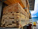 Holzlatten ordentlich gestapelt unter Dach, zeigen Lagerung von Baumaterialien f&uuml;r sp&auml;tere Verwendung