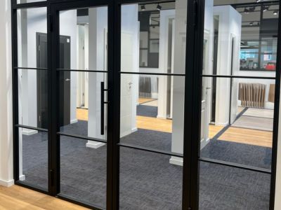 Modernes B&uuml;ro mit Glasw&auml;nden und T&uuml;ren, klare Linien und helle Beleuchtung zeigen funktionale Raumgestaltung