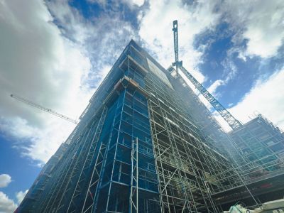 Gro&szlig;e Baustelle mit Ger&uuml;sten und Kran, Hochhaus im Rohbau, Betonstruktur und Baufortschritt deutlich erkennbar